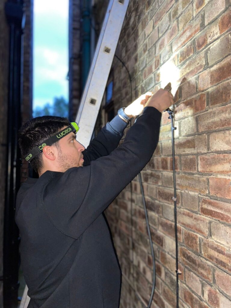 Emergency electrician repairing external wiring in London