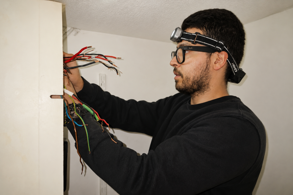 Electrician carrying out remedial wiring work in London