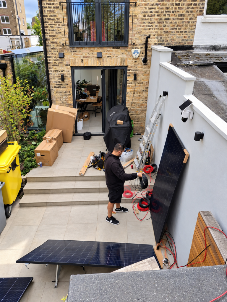 Electrician preparing solar cables for a garden solar panel installation in Harlesden, North West London