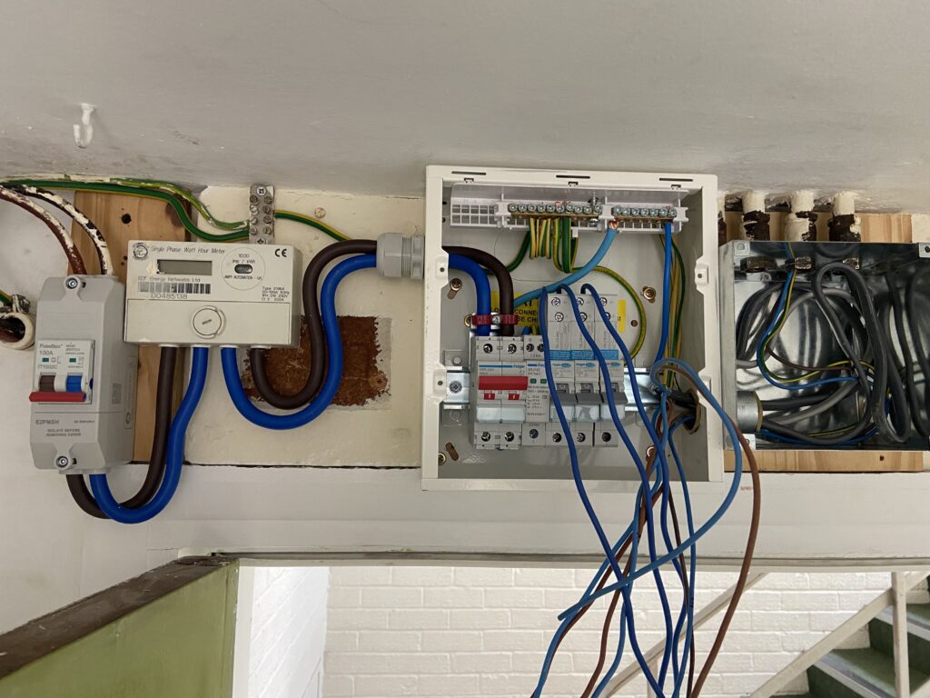 Old consumer unit before replacement by an electrician in Acton