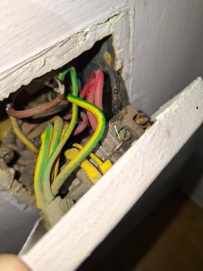 Heat-damaged wiring behind boiler switch found during EICR in Chiswick