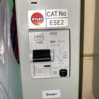 Unsafe shower consumer unit with damaged cable entry inspected by an emergency electrician in London