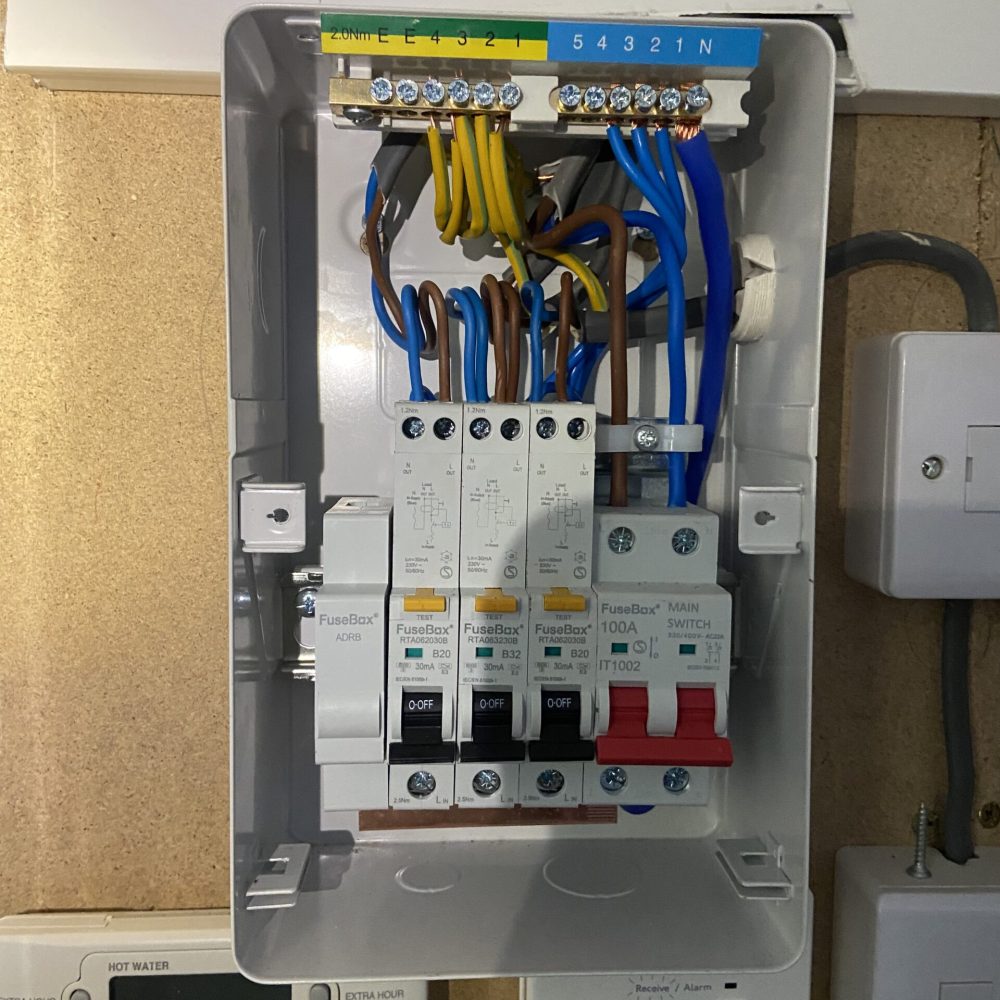 Open loft fuse board during installation by an electrician in Acton